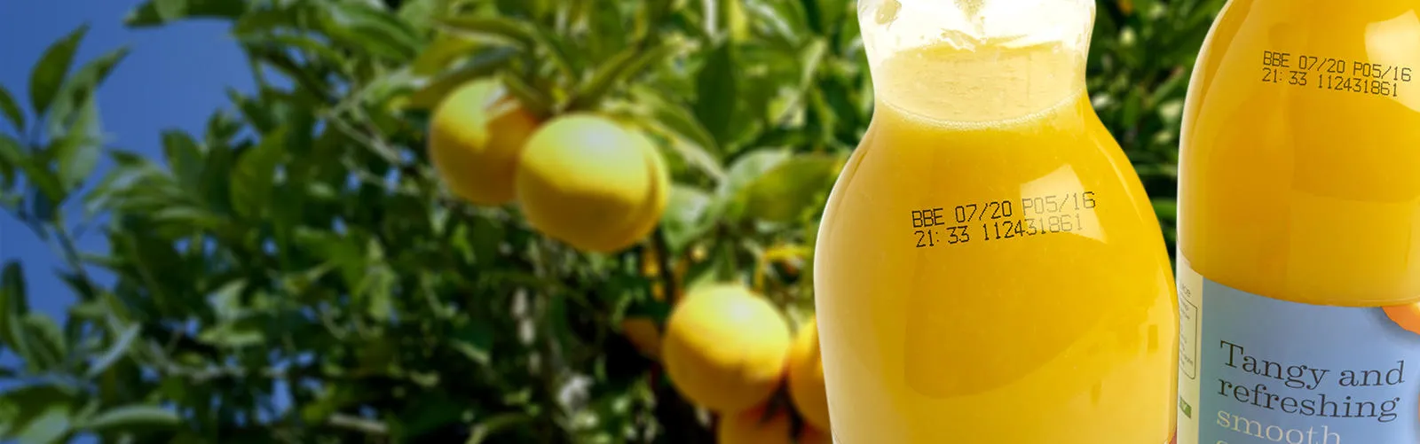 El código de la impresora de inyección de tinta continua negra en las botellas de plástico de jugo de naranja, incluyendo la fecha de caducidad