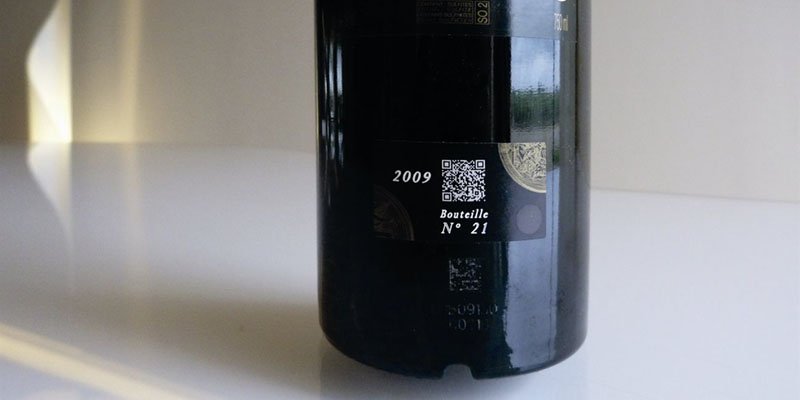Botella de vino tinto con código QR blanco impreso en el lateral